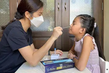 KE ARAH ENDEMIK: Pengujian kendiri kini merupakan salah satu strategi utama Singapura dalam menjadi sebuah negara yang berdaya tahan Covid-19. Kakitangan di tapak kerja dan murid sekolah adalah antara golongan yang perlu mengambil ujian swab kendiri menggunakan kit ART. - Foto BH oleh Alphonsus Chern