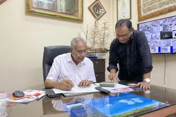 BERGANDING BAHU: Pengarah syarikat Har Yasin Restaurant Pte Ltd, Encik Mohamed Haneefa Iqbal (berdiri), bersama bapanya, Encik Mohamed Hanifa Abdul Hamid, pengerusi syarikat itu.