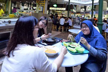 JAMU SELERA: Cik Nurul Mardiya makan tengah hari bersama rakan kerjanya di Lau Pa Sat yang tidak jauh dari stesen MRT Downtown. - Foto ZAINAL YAHYA