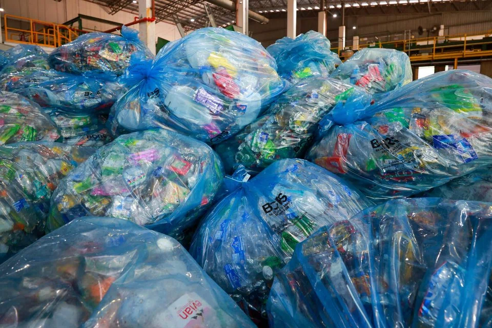 Timbunan beg mengandungi tin dan botol plastik yang telah dimampatkan di Kemudahan Pengiraan dan Pengisihan baharu Skim Pemulangan Bekas Minuman (BCRS) di Tuas.