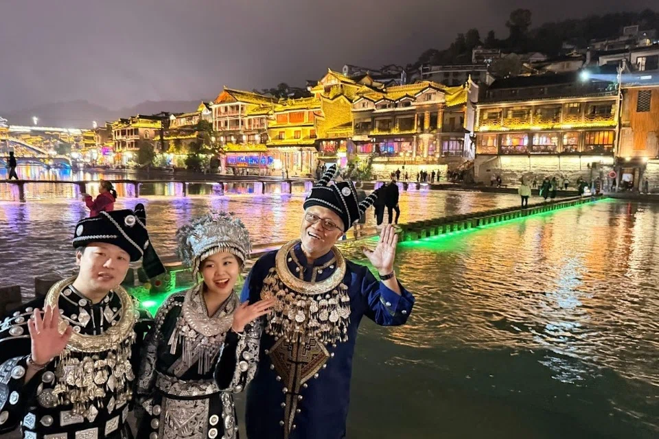 Encik Sujimy Mohamad (kanan) bergambar dengan mereka yang memakai pakaian tradisional di bandar purba Phoenix di Hunan.