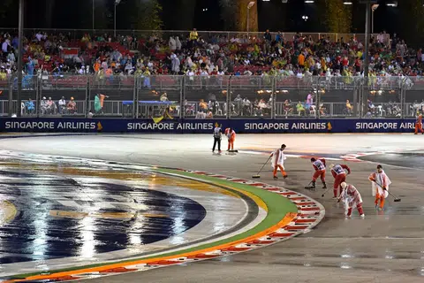 HUJAN TIDAK HALANG AKSI: Para petugas cuba mengeringkan balapan sebelum perlumbaan Grand Prix Singapura 2022 malam tadi. Perlumbaan F1 yang dijadual berlangsung pada 8 malam ditunda kira-kira sejam akibat hujan lebat. - Foto REUTERS