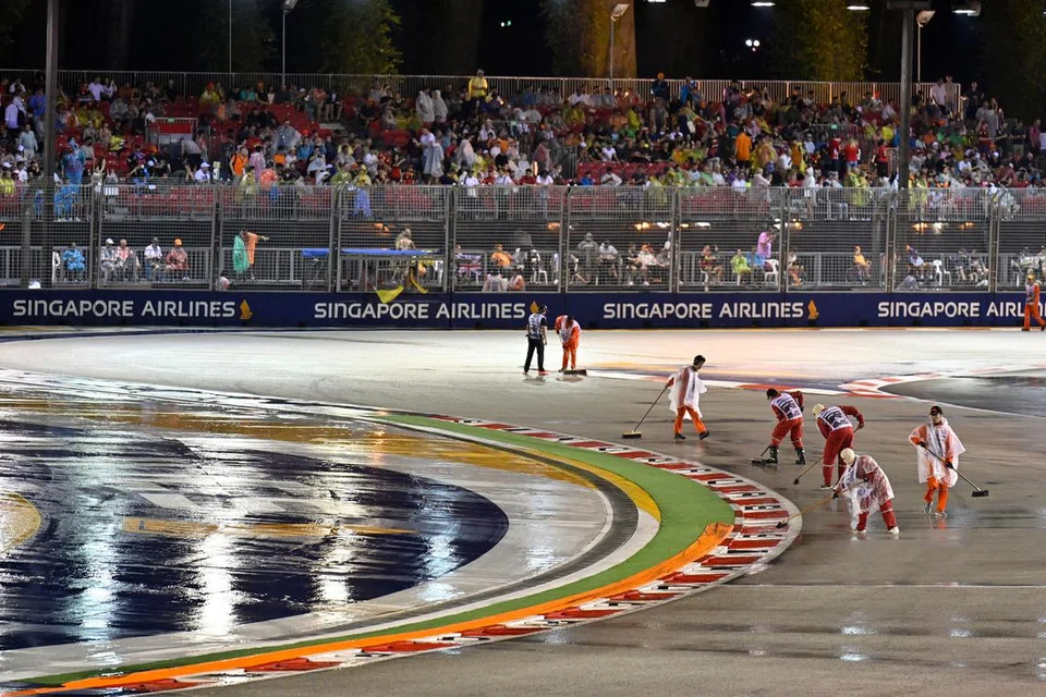 HUJAN TIDAK HALANG AKSI: Para petugas cuba mengeringkan balapan sebelum perlumbaan Grand Prix Singapura 2022 malam tadi. Perlumbaan F1 yang dijadual berlangsung pada 8 malam ditunda kira-kira sejam akibat hujan lebat. - Foto REUTERS