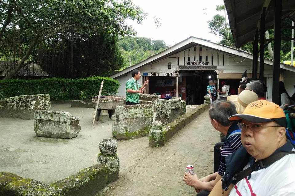 NEGERI DAN MENYERAMKAN: Para pelancong mendengar taklimat mengenai hukuman memengal kepala yang pernah dilaksanakan dalam zaman Batak kuno.