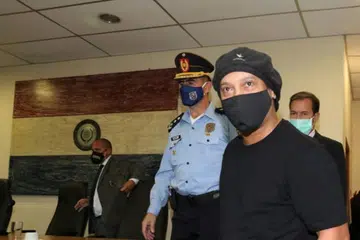 BEBAS BERSYARAT: Ronaldinho tiba di Mahkamah Keadilan Agung Paraguay kelmarin. Pendakwa mengesyaki abangnya, Roberto, tahu pasport yang mereka gunakan palsu. Hakim berkata beliau tidak melepaskan mereka daripada tuduhan, sebaliknya meluluskan permohonan melepaskan mereka sebagai langkah "menangguh prosedur undang-undang". - Foto REUTERS