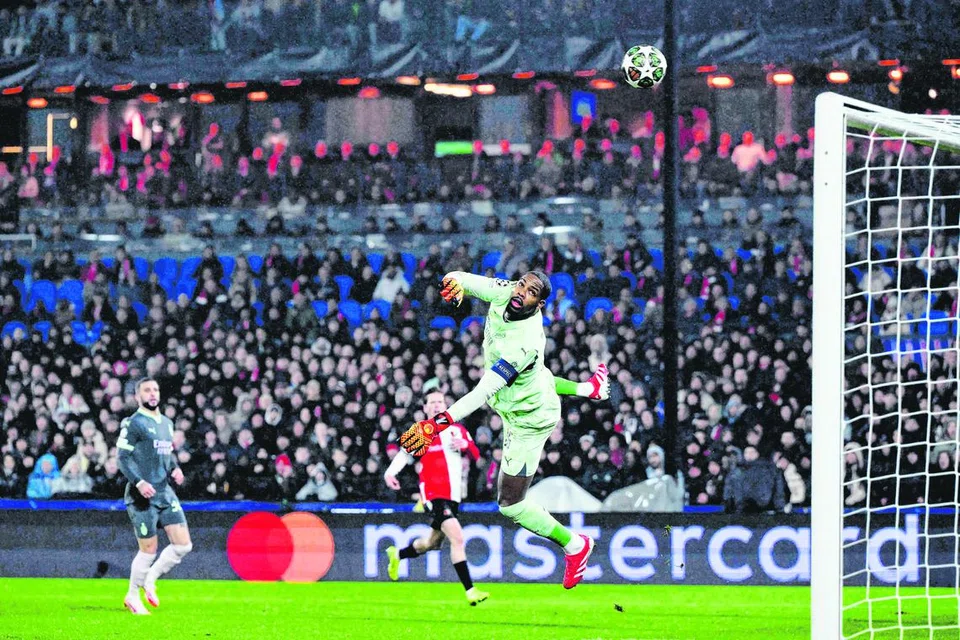 Penjaga gol AC Milan, Mike Maignan, melompat untuk menangkap bola semasa perlawanan pertama pusingan play-off peringkat kalah mati Liga Juara-Juara UEFA antara Feyenoord dengan AC Milan di Rotterdam, pada 12 Februari lalu.