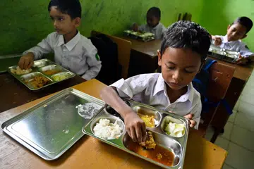 Murid dari sekolah dasar di Darul Kamal, wilayah Aceh, menikmati makanan agihan pemerintah Indonesia di bawah program makanan percuma yang teruk dikritik ekoran kesan keracunan makanan yang menjejas ribuan pelajar di seluruh negara.