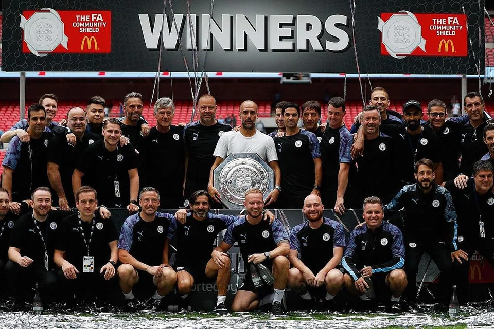 PERTAHANKAN MAHKOTA: Pengurus City, Guardiola (tengah) memegang trofi Perisai Masyarakat selepas berjaya menundukkan seteru utama mereka di dalam liga, Liverpool 5-4 menerusi tendangan penalti penentuan. - Foto AFP