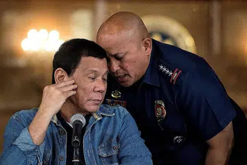 HADAPI SIASATAN: Gambar Januari 2017 ini menunjukkan Presiden Filipina, Encik Rodrigo Duterte (kiri) mendengar bisikan pengarah agung Polis Nasional Filipina ketika itu, Encik Ronald Dela Rosa, semasa satu sidang media di Istana Malacanang di Manila. - Foto AFP