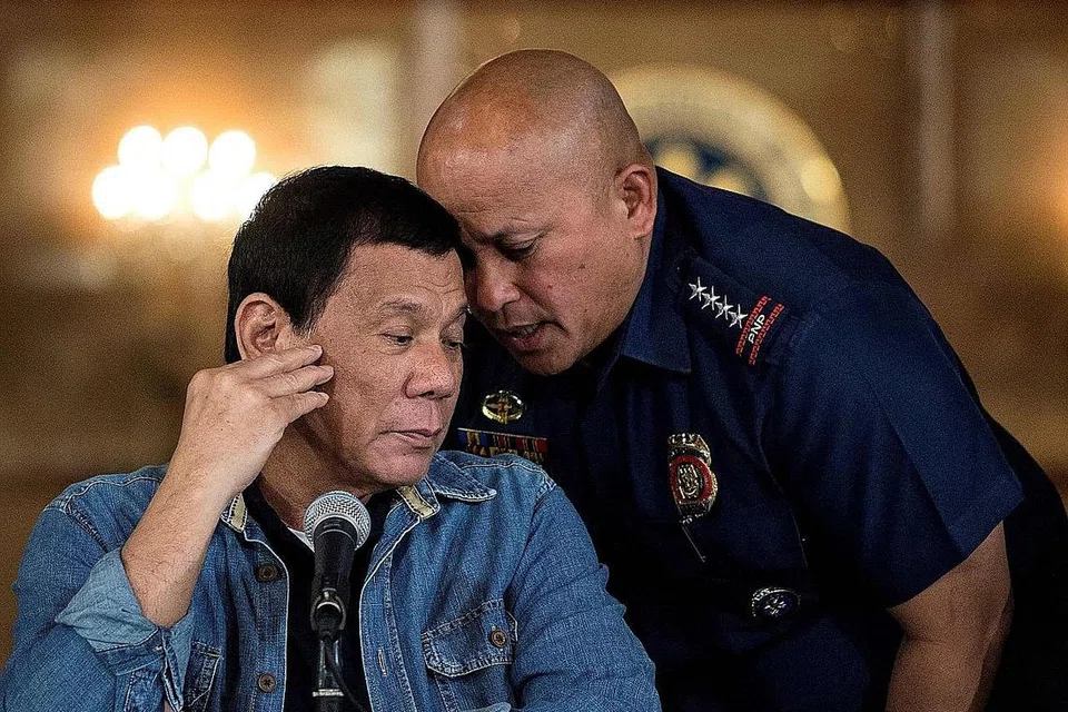 HADAPI SIASATAN: Gambar Januari 2017 ini menunjukkan Presiden Filipina, Encik Rodrigo Duterte (kiri) mendengar bisikan pengarah agung Polis Nasional Filipina ketika itu, Encik Ronald Dela Rosa, semasa satu sidang media di Istana Malacanang di Manila. - Foto AFP