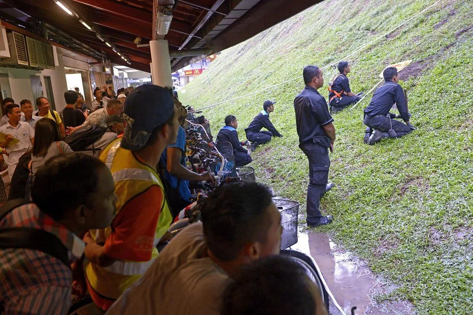 Pekerja syarikat pembunuh serangga Star Pest Control berusaha menghapuskan tikus dan lubang tikus dekat stesen MRT Bukit Batok pada 18 December 2014.