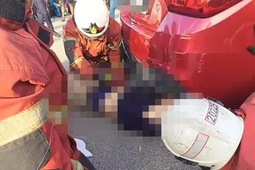 Anggota bomba mengeluarkan mayat seorang lelaki warga emas yang tersepit di bawah sebuah kereta Proton Saga yang mengundur sendiri dipercayai kerana tidak ditarik brek tangan di Shah Alam, Selangor, pada petang 27 Mei.