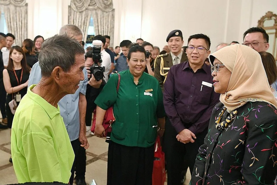 SUMBANGAN DIIKTIRAF: Presiden Halimah Yacob (kanan) beramah tamah dengan penerima Anugerah Bintang Khidmat Sekitaran (ES), termasuk penyelia di Horsburgh Integrated Services, Cik Rahmatunnisha Mohamed Abdul Karim (berbaju hijau), dalam majlis Hari Tenaga Kerja ES di Istana semalam.- Foto BM oleh KHALID BABA