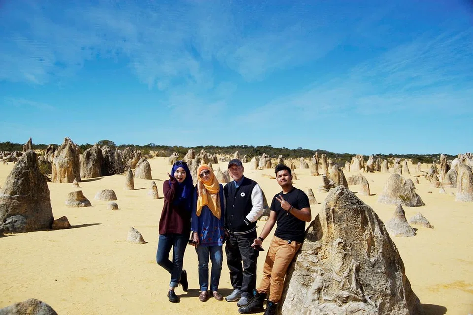 PEMANDANGAN MENAKJUBKAN: Wartawan (atas) dan keluarga semasa mengunjungi Padang Pasir Pinnacles yang dipenuhi batu-bata pelbagai saiz dan bentuk. - Foto ihsan SITI AISYAH NORDIN