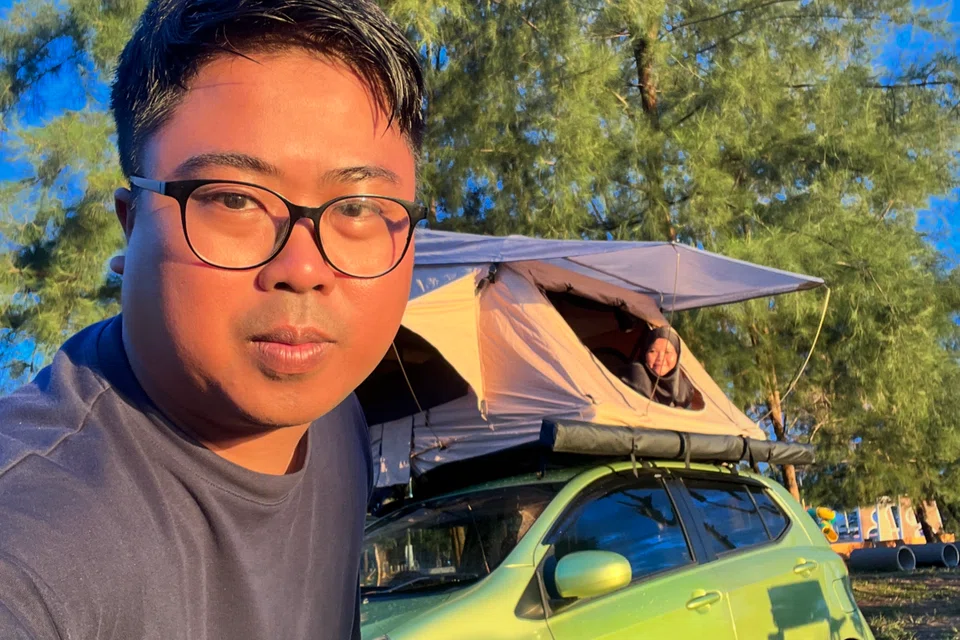 Encik Fajar dan Cik Noor Asyikin Muhamad Saer memuatkan khemah di atas kereta mereka.