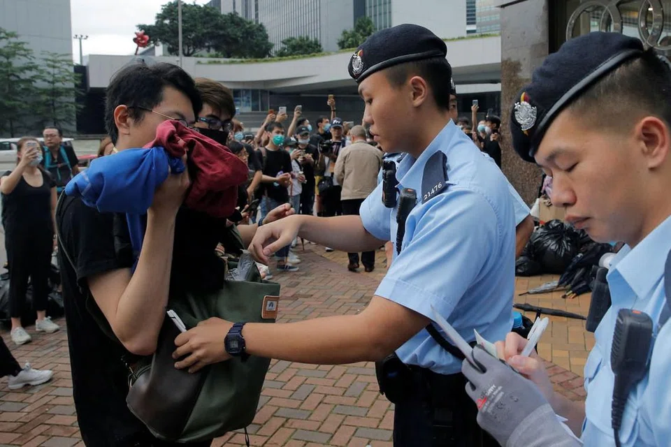 KAWALAN KETAT: Pegawai polis memeriksa beg seorang pejalan kaki ini di Hongkong semalam - sehari selepas insiden keganasan yang menyaksikan penunjuk perasaan bertempur dengan polis. - Foto REUTERS