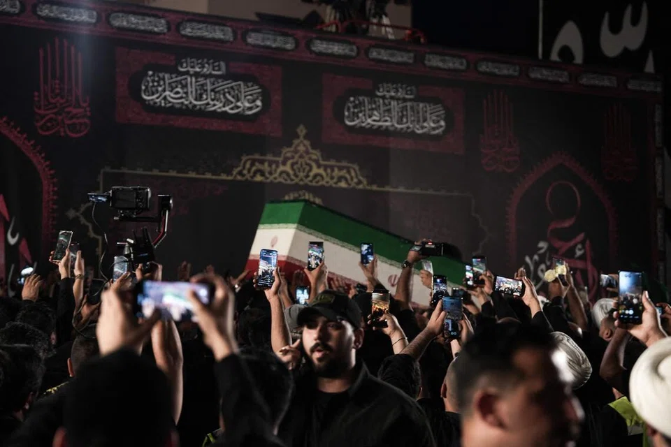 Orang ramai menggunakan telefon bimbit untuk merakam ketibaan keranda bekas Pemimpin Tertinggi Iran, Ali Khamenei, di Lapangan Terbang Antarabangsa Najaf, Iraq, pada 7 Julai 2026. Jenazah Khamenei diterbangkan ke bandar suci Najaf sebagai sebahagian daripada siri upacara penghormatan dan perarakan pengebumian di bandar-bandar suci Syiah yang menempatkan makam paling dihormati oleh umat Islam Syiah.