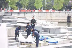 PENEMUAN MAYAT: Anggota polis mengangkat sekujur mayat yang ditemui di Sungai Singapura pagi tadi. - Foto THE STRAITS TIMES