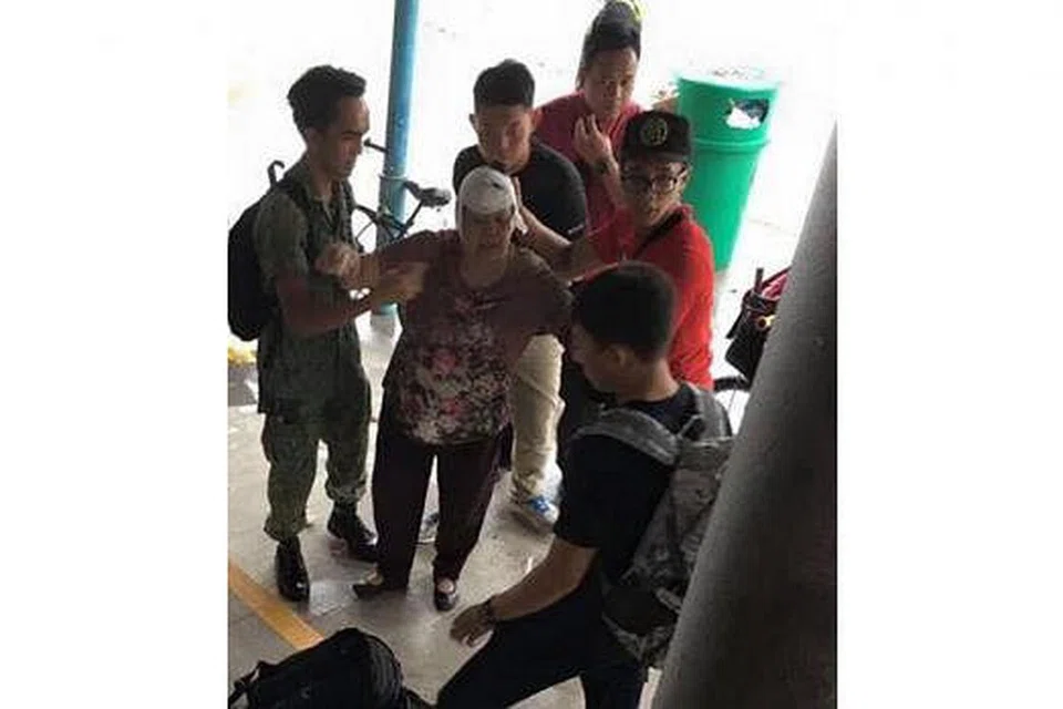 BERBAKTI TAK KIRA MASA, TEMPAT: 3SG Fahmi (berpakaian seragam) dan 3SG Mohammad Zulfadli (topi hitam) membantu wanita yang cedera akibat terjatuh dekat stesen MRT Yishun ke ambulans. - Foto ASHRAF ALI KHAN