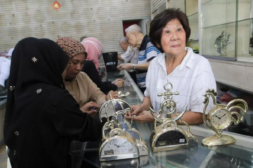 Pemilik kedai jam di Kota Bharu, Kelantan, Cik Tan Siew Wan, 75 tahun (kanan), melayan pelanggan ketika kedainya membuat lelongan untuk menutup kedai selepas 70 tahun operasi. 