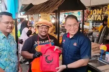 Pengerusi Jawatankuasa Kesihatan dan Alam Sekitar Johor, Encik Ling Tian Soon (kanan), menyerahkan apron dan bahan pendidikan kesihatan kepada peniaga semasa meninjau bazar Ramadan Angsana Mall, Johor Bahru, pada 6 Mac. 
