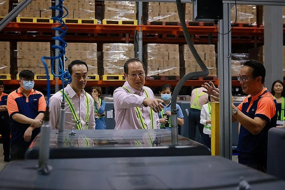 BERAS DILINDUNG DARI PEROSAK: (dari kiri) Dr Koh, Dr Tan, mengunjungi kemudahan SSW di Pasir Panjang Rd, dan mendengar penjelasan daripada Encik Ong mengenai Teknologi Kotak MAP, di mana oksigen dikeluarkan dari kotak sementara gas lengai dipam ke dalamnya. - Foto BH oleh JASON QUAH