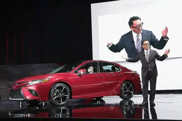 PROMOSI KERETA: Encik Akio Toyoda sedang memperkenalkan kenderaan baru Camry 2018 di Pameran Automotif Detroit. - Foto AFP