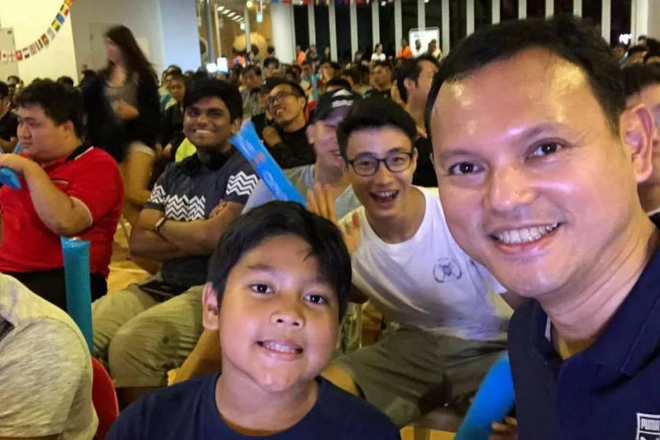 BERSAMA PEMINAT: Menteri Negara (Tenaga Manusia merangkap Pembangunan Negara), Encik Zaqy Mohamad yang juga merupakan Anggota Parlimen GRC Chua Chu Kang mengunjungi Kelab Masyarakat Keat Hong yang dibanjiri sekitar 2,000 penduduk Chua Chu Kang untuk menonton perlawanan akhir Piala Dunia malam kelmarin. 