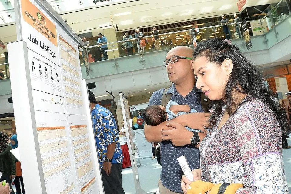 CARI KERJA: Beberapa pengunjung meneliti senarai jawatan kosong yang ditawarkan di pesta kerjaya di OneKM Mall. - Foto JOHARI RAHMAT