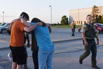 SALING BERI SOKONGAN: Beberapa orang berdakapan dekat Gereja Cornerstone, di bandar Ames, Iowa, selepas kejadian tembakan yang menyebabkan tiga orang maut, termasuk seorang penyerang yang bunuh diri, di luar gereja itu. - Foto REUTERS