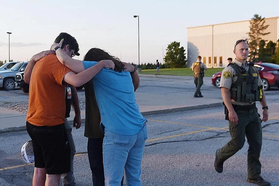 SALING BERI SOKONGAN: Beberapa orang berdakapan dekat Gereja Cornerstone, di bandar Ames, Iowa, selepas kejadian tembakan yang menyebabkan tiga orang maut, termasuk seorang penyerang yang bunuh diri, di luar gereja itu. - Foto REUTERS