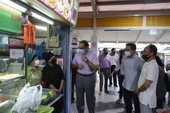 TANYA PERKEMBANGAN DIGITAL: Encik Iswaran (tiga dari kiri) bertanya pegerai di pusat penjaja dan pasar di Blok 210 Toa Payoh Lorong 8 tentang perkembangan penggunaan e-bayaran kod SG QR di gerai makan mereka. - Foto BH oleh TIMOTHY DAVID