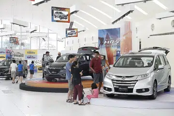 MELIHAT KERETA IDAMAN: Bakal pembeli kereta melihat-lihat kereta Honda yang dijual di bilik pameran Honda di Alexandra Road. - Foto fail THE STRAITS TIMES