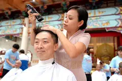 BERI SOKONGAN: Ketua Pegawai Eksekutif Yayasan Barah Kanak-Kanak (CCF), Encik Koh Shukai (kiri), mencukur rambut buat kali pertama sempena acara ‘Hair for Hope’ pada 19 April. Rambut beliau dicukur  Anggota Parlimen GRC Bishan-Toa Payoh (Bishan East-Sin Ming), Cik Elysa Chen.
