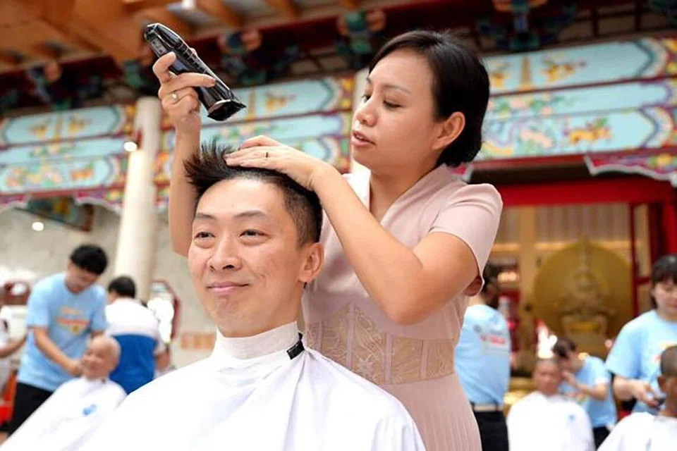 BERI SOKONGAN: Ketua Pegawai Eksekutif Yayasan Barah Kanak-Kanak (CCF), Encik Koh Shukai (kiri), mencukur rambut buat kali pertama sempena acara ‘Hair for Hope’ pada 19 April. Rambut beliau dicukur  Anggota Parlimen GRC Bishan-Toa Payoh (Bishan East-Sin Ming), Cik Elysa Chen.