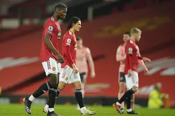 WAJAH KECEWA: Pemain Manchester United Paul Pogba (kiri) dan Edinson Cavani meninggalkan padang dalam kekecewaan selepas kekalahan memeranjatkan 2-1 di tangan Sheffiled United. - Foto EPA-EFE 