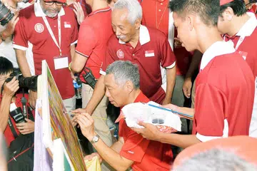 SENIMAN BERDEDIKASI: Perdana Menteri Lee Hsien Loong bersama Encik Sarkasi Said dalam acara Hari Kebangsaan di Institut Pendidikan Teknikal (ITE) pada 2015. - Foto FAIL