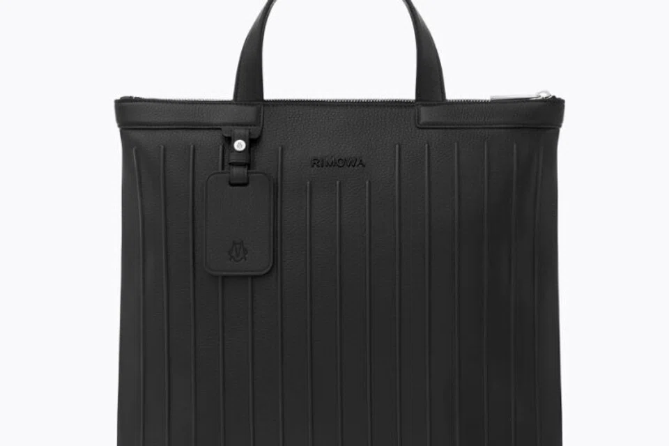 Beg Tote Kulit Berzip Rimowa Never Still hanya tersedia dalam warna hitam.