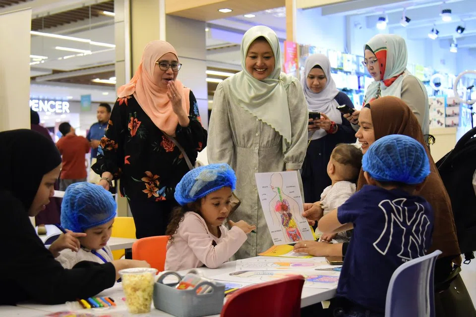 MINDA KREATIF: Setiausaha Parlimen Kanan (Kesihatan merangkap Undang-undang), Cik Rahayu Mahzam (tengah) mengunjungi Makmal Biologi Cilik yang mengajak kanak-kanak menghasilkan sistem pencernaan manusia menggunakan bahan kitar semula.