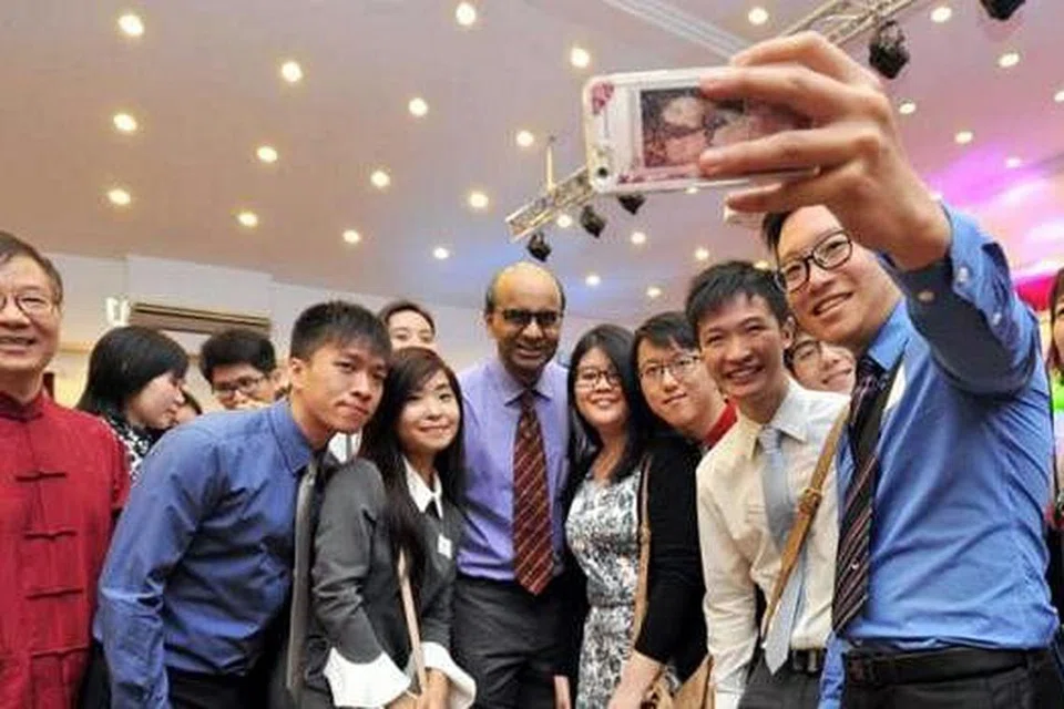 AMBIL PERHATIAN TERHADAP BUDAYA: Encik Tharman merakam 'wefie' bersama pelajar UniSIM semasa sambutan Tahun Baru Cina tahunan yang dianjurkan oleh Persekutuan Persatuan Suku Kaum Cina Singapura (SFCCA), Perniagaan China dan Pusat Kebudayaan Cina Singapura. - Foto THE STRAITS TIMES