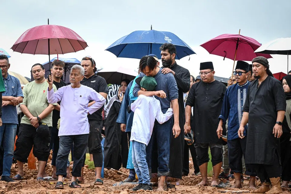 IRINGAN TERAKHIR: Suami Allahyarhamha Nur Aisyah Md Akbar, Encik Abdul Rauf Mohd Said, memeluk anak bongsunya, Yusoff Aidan Abdul Rauf, semasa pengebumian arwah isterinya pada 27 Disember.