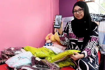 CARA MENARIK: Ketika pertama kali menonton pengguna lain membuat penjualan 'live' di Facebook, Cik Noor Aishah (atas) mendapati kaedah ini cara menarik baginya menambah pendapatan, justeru mendorongnya cuba-cuba untuk menjual barangan di Facebook 'Live'. - Foto BH oleh KHALID BABA