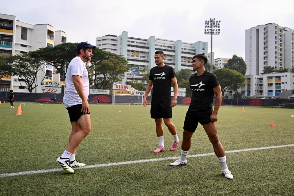 Pemain Tanjong Pagar United (dari kanan) Taufik Suparno dan Boris Kopitovic mendapat pencerahan daripada ketua jurulatih mereka, Miquel Llado.