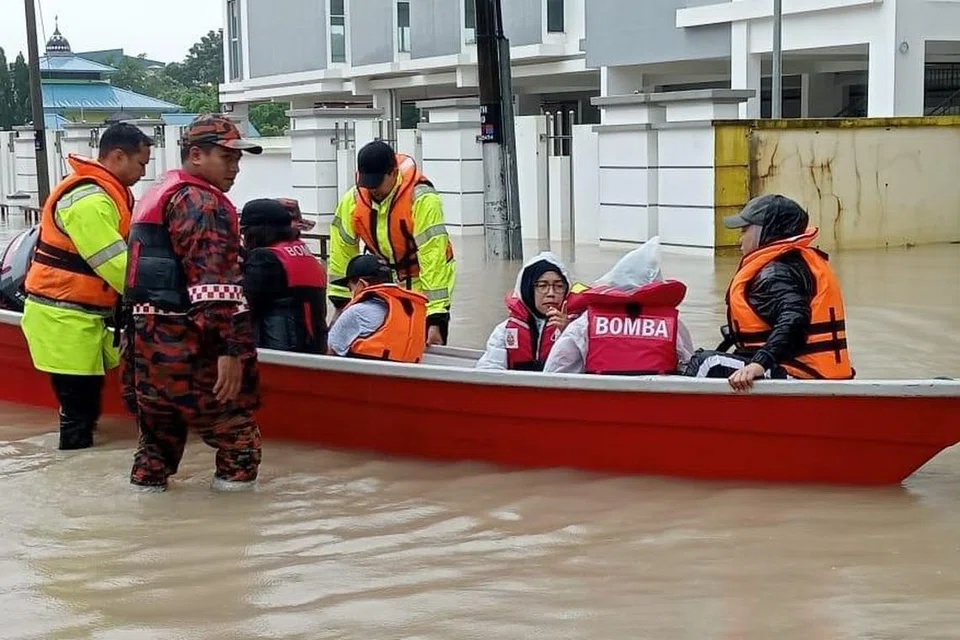 BANTU SELAMATKAN: Kerjasama anggota Polis Kota Tinggi bersama Jabatan Bomba dan Penyelamat Malaysia Kota Tinggi membantu pindahkan mangsa banjir di sekitar Jalan Niaga, Kota Tinggi, Johor pada 9 Januari.