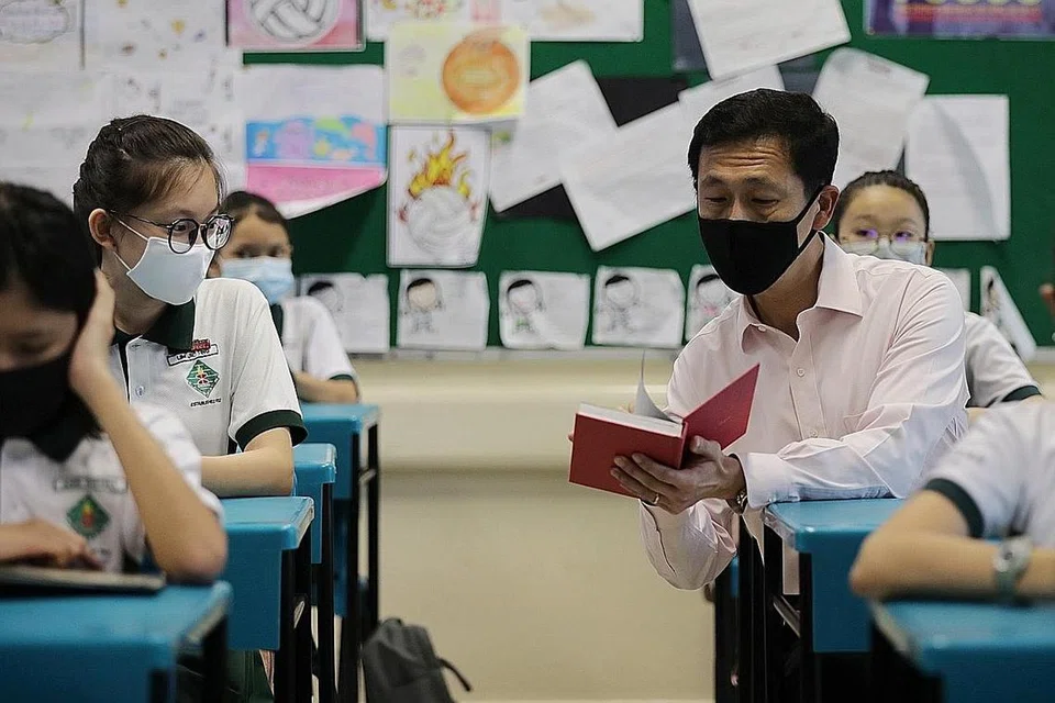 KEMBALI KE SEKOLAH: Menteri Pendidikan Encik Ong Ye Kung berbual dengan dengan murid Sekolah Rendah Xingnan, Lim Jie Ting pada hari pertama sekolah dibuka semula selepas tempoh pemutus litar. - Foto BH oleh Gin Tay