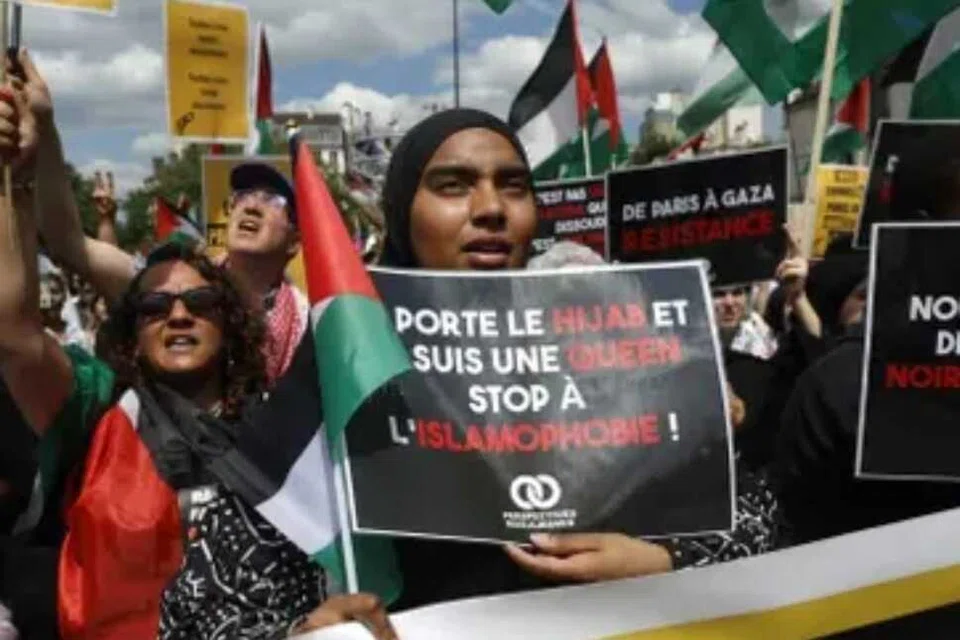 Seorang penunjuk perasaan memegang plakad antara lain tertulis “hentikan Islamofobia” ketika menyertai perhimpunan membantah Islamofobia di Paris pada 11 Mei 2025. 