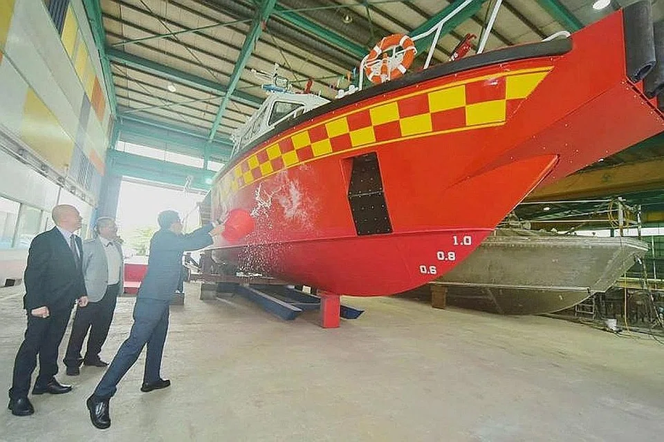 LANCARKAN KAPAL RFV BARU: Pesuruhjaya SCDF Eric Yap menyimbah air laut pada permukaan kapal White Swordfish. Adat itu merupakan tradisi yang dilakukan sebagai tanda nasib baik dan ucap selamat. - Foto FACEBOOK SCDF
