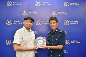 SELAMATKAN NYAWA: Encik Mohamed Juhairi Juma'at (kiri) menerima Anugerah Semangat Kemasyarakatan Awam (PSA) daripada Pembantu Pesuruhjaya Polis (AC) Jarrod Pereira (kanan), Komander Divisyen Polis Clementi. - Foto BH oleh NG SOR LUAN