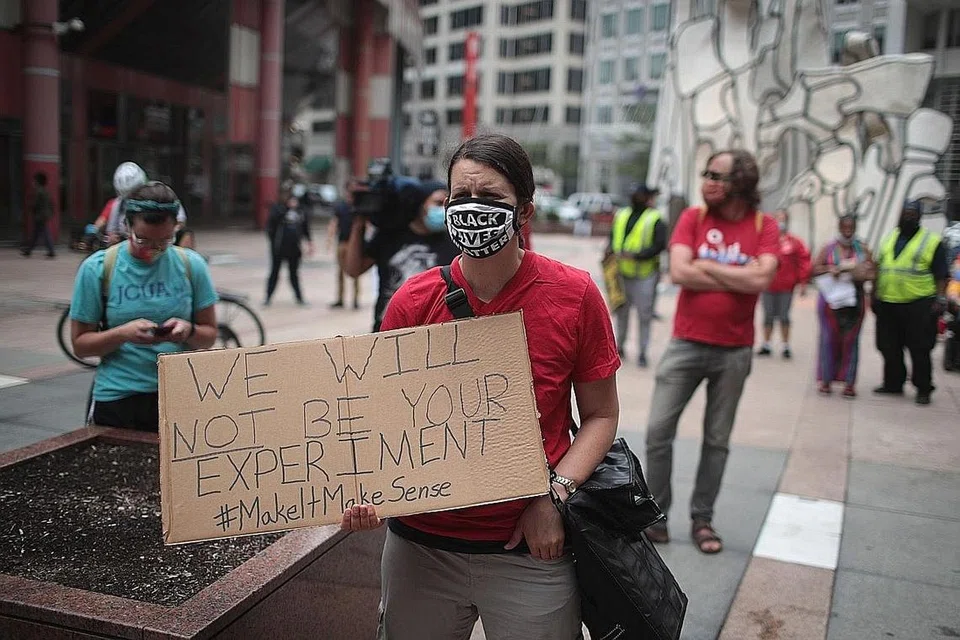 MAHU SEKOLAH TERUS DITUTUP: Penunjuk perasaan melakukan bantahan di Dewan Bandaraya di Chicago, Illinois. Mereka minta sekolah awam terus ditutup sehingga terdapat data saintifik menyokong pembukaan semula sekolah. - Foto AFP