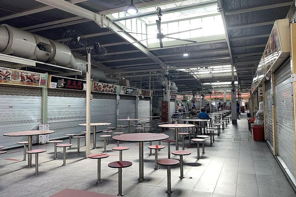 BANYAK GERAI TUTUP: Kurang suku daripada 80 gerai di pusat penjaja di Blok 210, Toa Payoh Lorong 8 ini beroperasi, dengan ramai penjaja memilih untuk tidak membuka kedai kelmarin sejak premis itu ditutup bagi kerja pembersihan. - Foto SHIN MIN